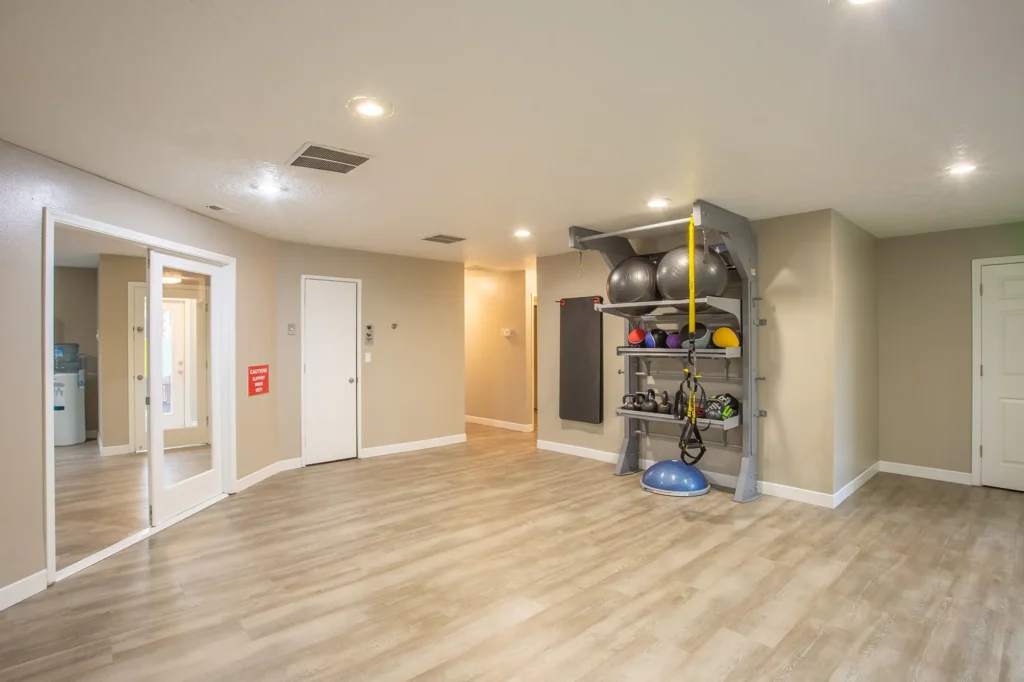 Fitness center with free weights and TRX trainer, lots of windows