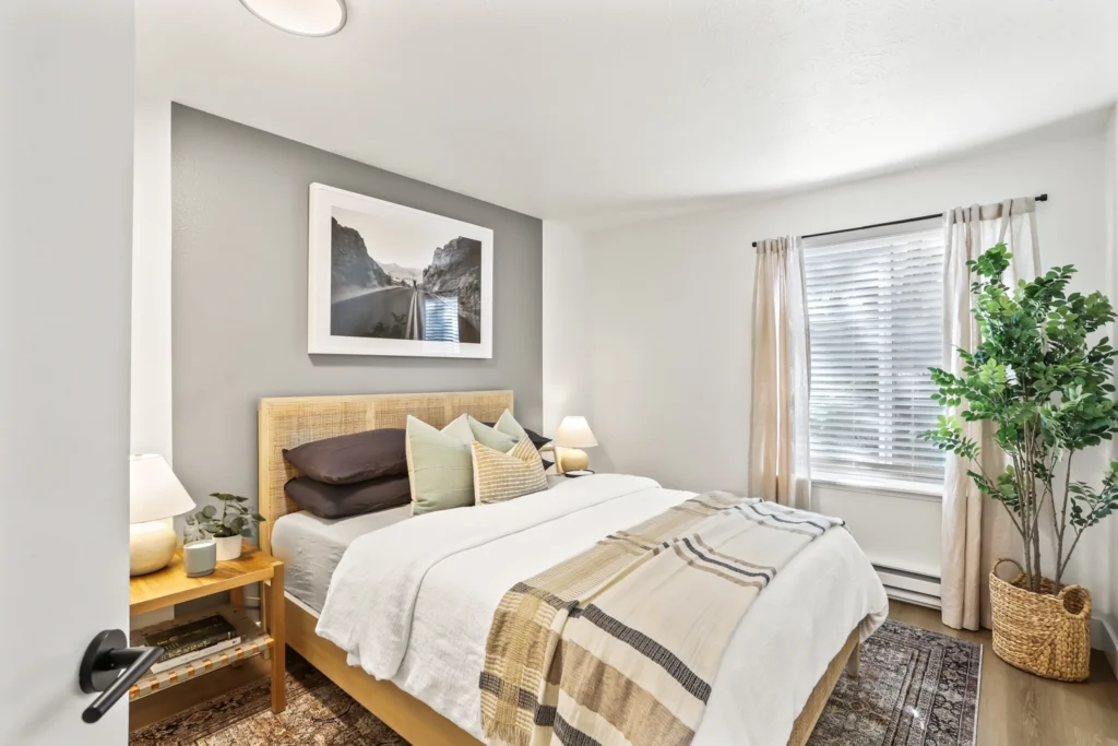 Bedroom with modern furniture, wood-style flooring, and window.