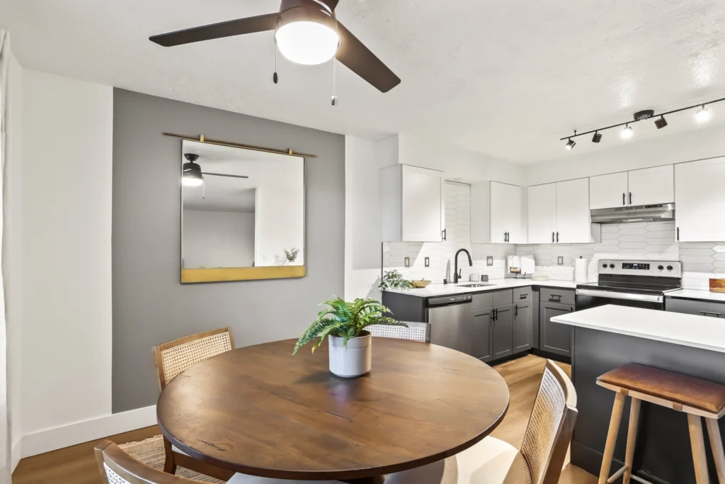 Dining area near kitchen and living room with natural light and ceiling fan.
