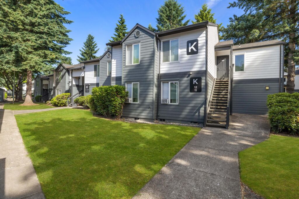 Exterior view of apartment building with trees and sidewalks